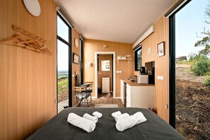 Una habitación con cama, kitchenette pequeña y vistas al exterior.