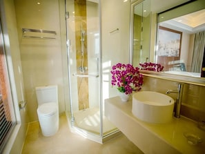 Un bagno moderno con doccia vetro, un water e un mobile lavabo con lavandino e specchio.