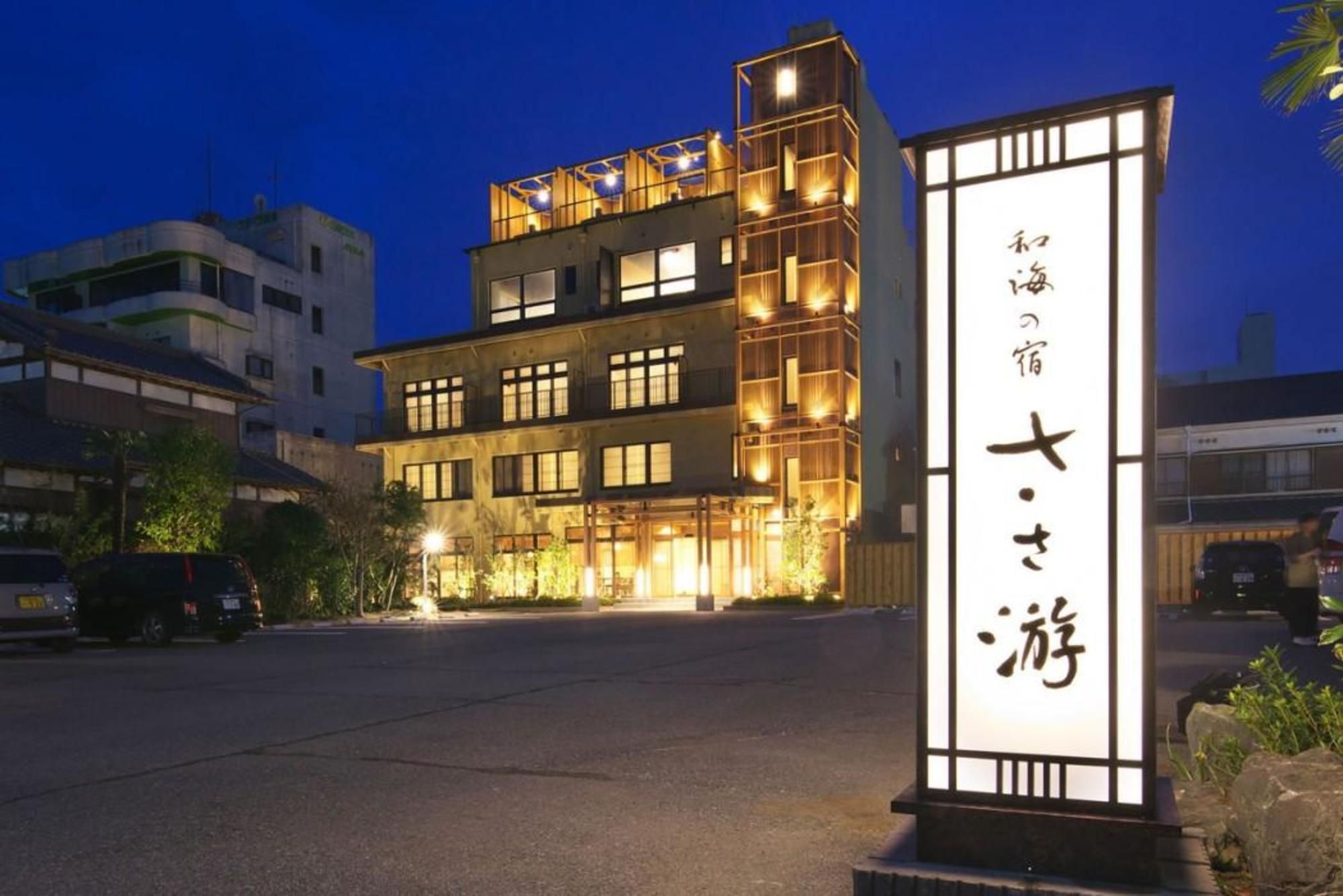 Un hôtel à plusieurs étages, doté d’une enseigne lumineuse et d’un parking situé en avant.