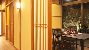A dining area with a table set for two, featuring a view of a garden through a large window. - Sasayu (Shirako)
