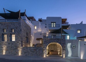 A modern building with stone walls, a balcony, and a welcoming entrance. - Saluti Da Stampalia (Astypalaia)