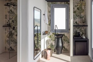 A bathroom with a large mirror, a window, a sink, and a shower area. - Saluti Da Stampalia (Astypalaia)