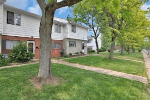 A residential area with two-story houses, a well-maintained lawn, and mature trees. - Jackie's Green Parkside Mansfield Townhouse (Mansfield)