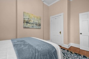 A bedroom with a bed, a painting, and a white door. - Hannah's Haus Historic German Village 3BR+Parking (Columbus)