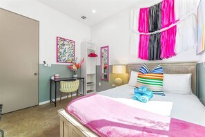 Une chambre d’hôtel comprenant un lit, une table de chevet, une chaise, un bureau et une armoire.