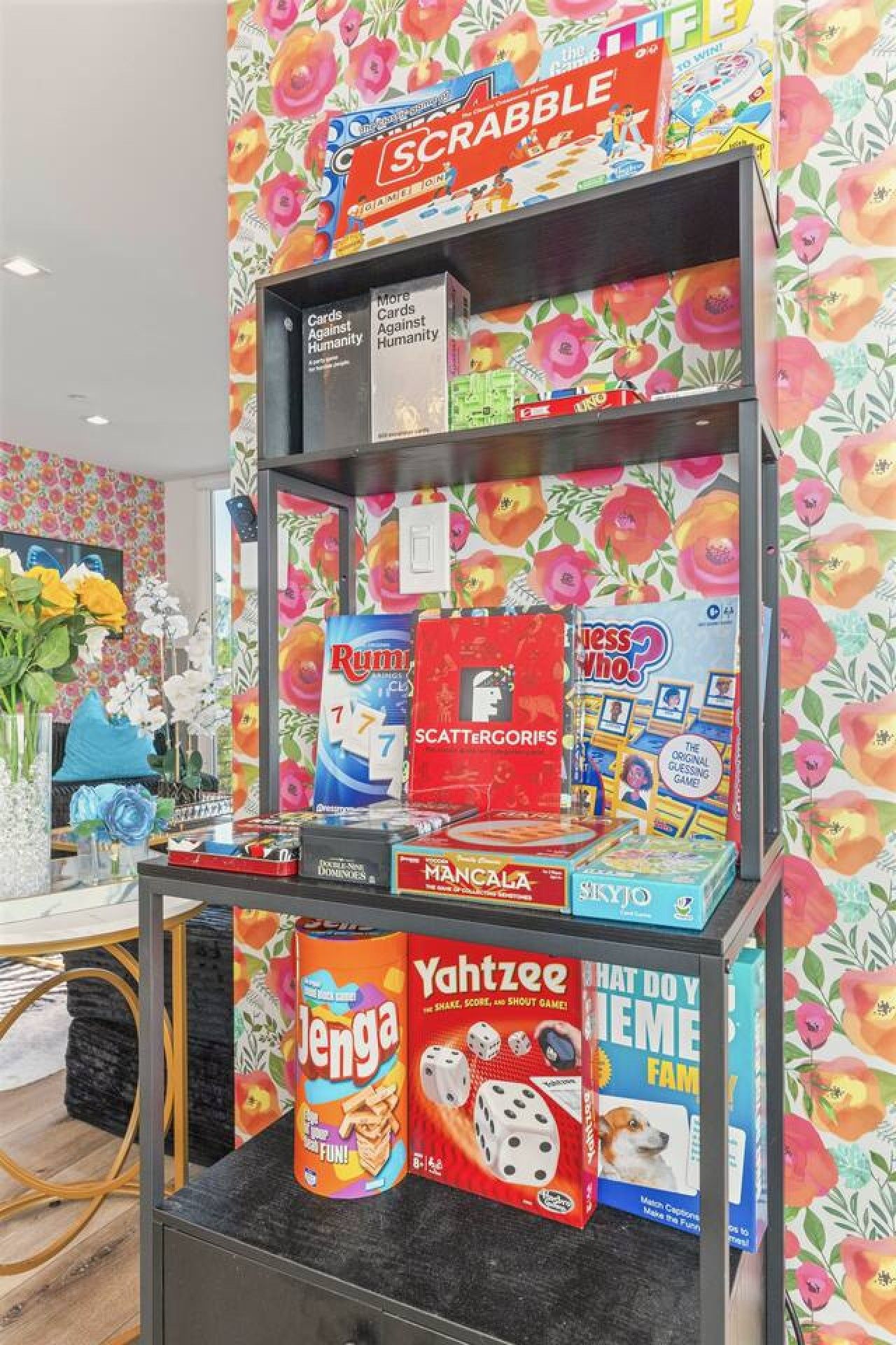A shelf with various board games including Scrabble, Rummikid, and Yahtzee.