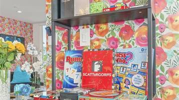 A shelf with various board games including Scrabble, Rummikid, and Yahtzee.