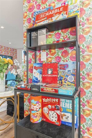 A shelf with various board games including Scrabble, Rummikid, and Yahtzee.
