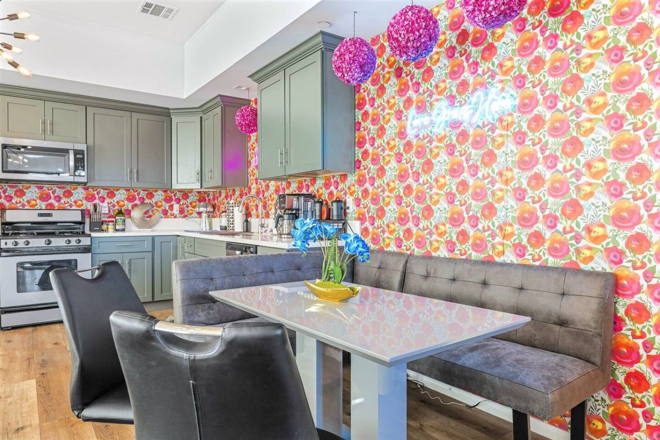 A modern kitchen with grey cabinets, a stainless steel microwave, and a gas stove.