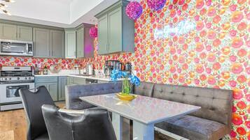 A modern kitchen with grey cabinets, a stainless steel microwave, and a gas stove.