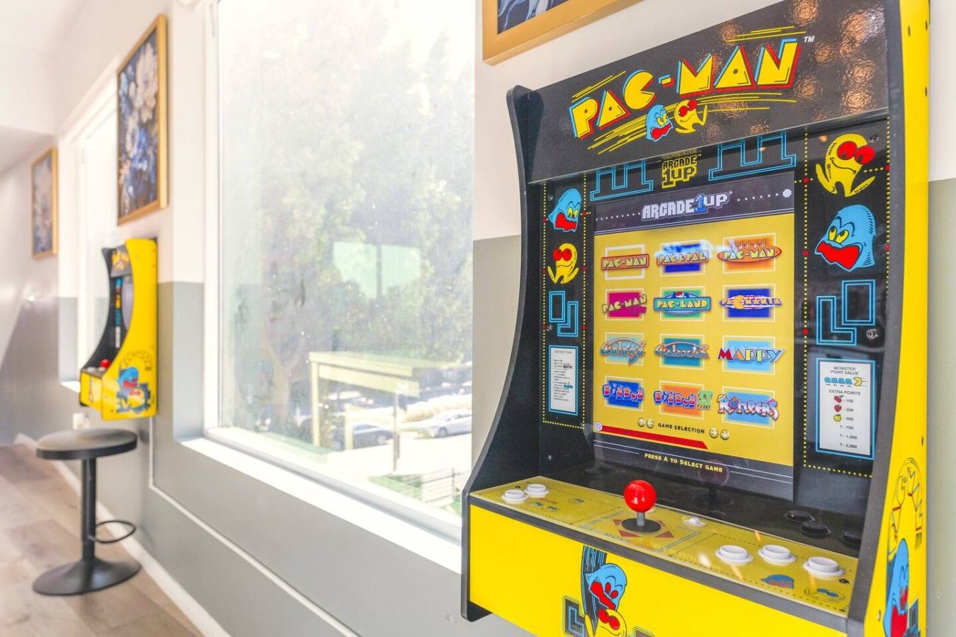 Pac-Man Spielautomaten und andere Spiele in einem Raum mit großen Fenstern.