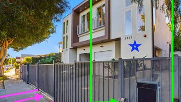 A modern two-story building with a gated entrance, a blue star symbol, and a garage door.