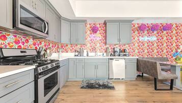 A kitchen with grey cabinets, a microwave, a stove, and a dishwasher.