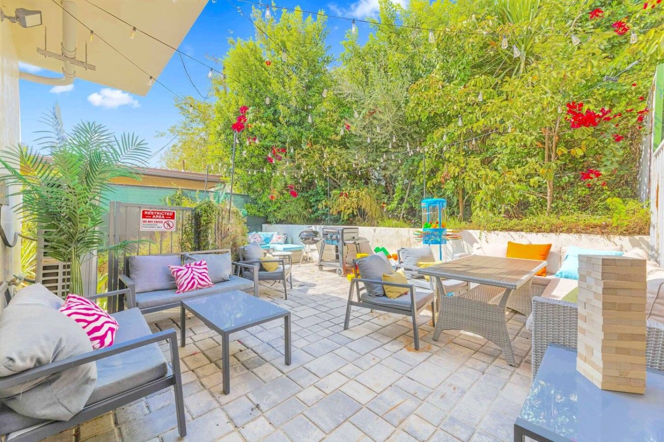 Une terrasse extérieure avec une table à manger, des chaises et un barbecue.