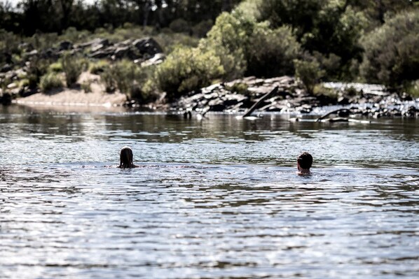 A river with two individuals swimming.