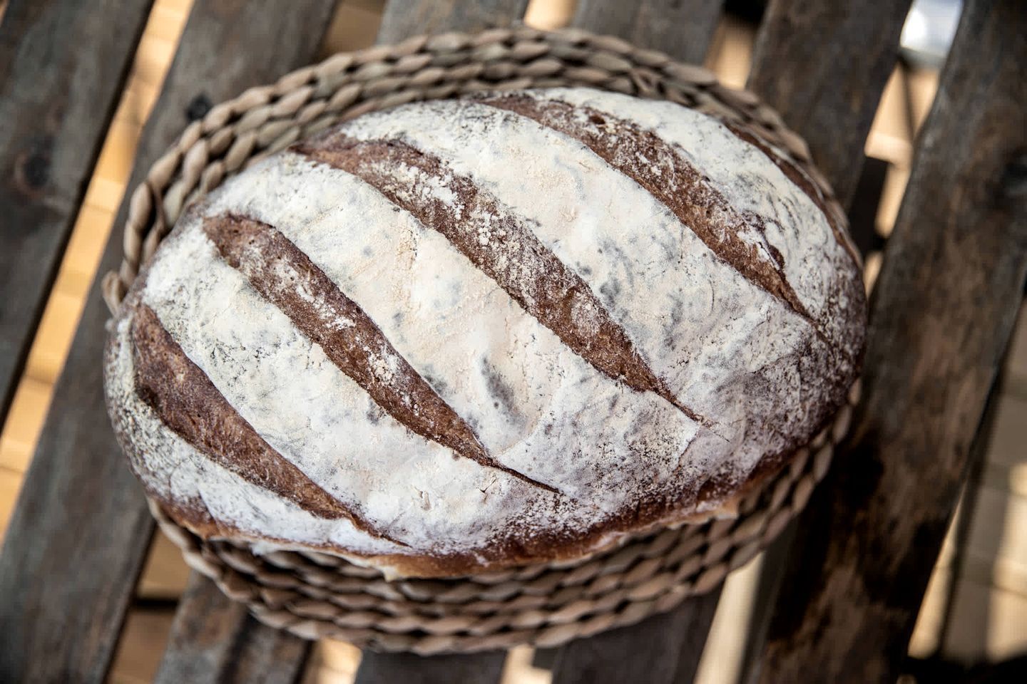 Ein Brot mit diagonalen Linien in einem gewebten Korb.