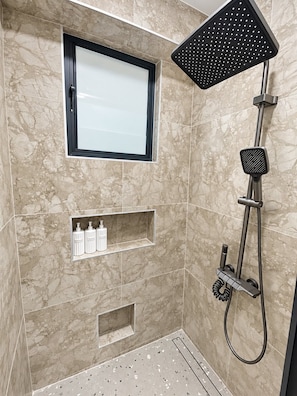 A modern bathroom with a shower, a window, and built-in shelves. - 2-bedroom apartment in peaceful Nasoso Nadi with AC comfort (Nasoso Nadi)