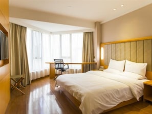 Ein Hotelzimmer mit einem großen Bett, einem Schreibtisch und einem Stuhl.