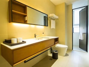 Ein modernes Badezimmer mit einem Holzlager, einem Waschbecken, einem Spiegel, einer Toilette und einem Mülleimer.