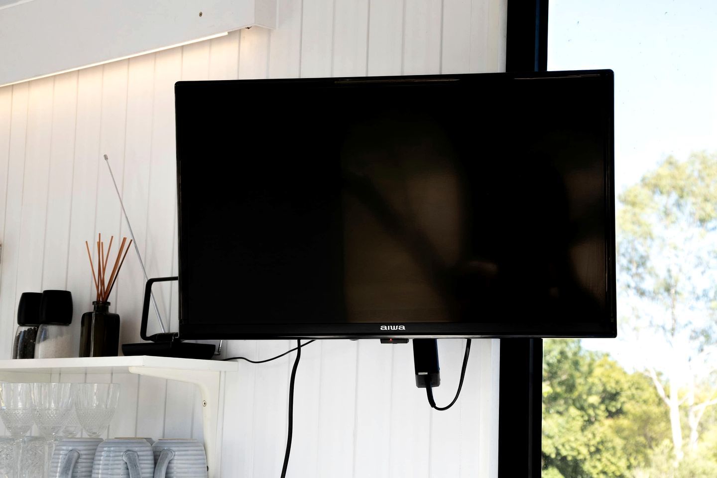 Ein Flachbildfernseher an der Wand montiert, mit angeschlossenem Kabel.
