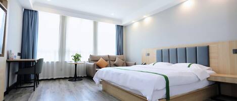 Una habitación de hotel moderna con una cama grande, un escritorio y una silla.