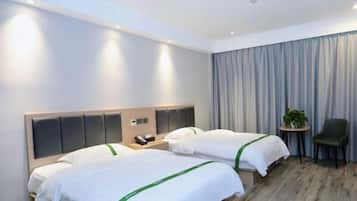 A hotel room with two beds, a small table, a chair, and a curtain.