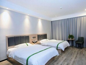 A hotel room with two beds, a small table, a chair, and a curtain. - Greentree Inn Xuancheng Langxi Guogou Plaza North Gate Express Hotel (Xuancheng)