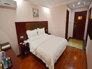 Ein Hotelzimmer mit einem Bett, einem Nachttisch und einem Schreibtisch mit Stuhl.