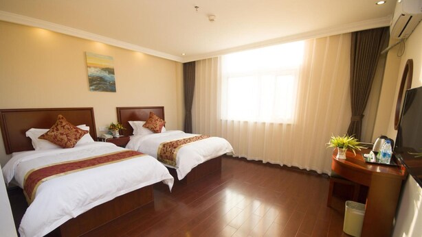 A hotel room with two beds, a TV, a desk with a plant, and a window with curtains. - Greentree Inn Xuancheng Langxi Guogou Plaza North Gate Express Hotel (Xuancheng)