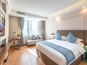 A hotel room with a large bed, bedside tables, a seating area, and a window with curtains. - Gem Fuyang City Linquan County Jiangziya Plaza Hotel (Fuyang)