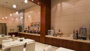 Um hall de hotel moderno com uma recepção, área de estar e um canto para café.