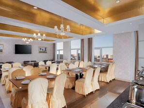 A conference room with tables and chairs, a flat-screen TV, and a city view. - Vienna 3 Best Hotel (Tianjin)