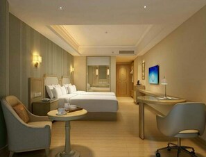A hotel room with a bed, two bedside tables, a desk, a chair, a small round table, and a wall-mounted lamp. - Vienna 3 Best Hotel (Tianjin)