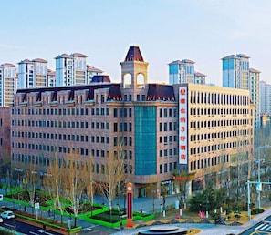 A multi-story hotel with a prominent tower and a large glass facade. - Vienna 3 Best Hotel (Tianjin)