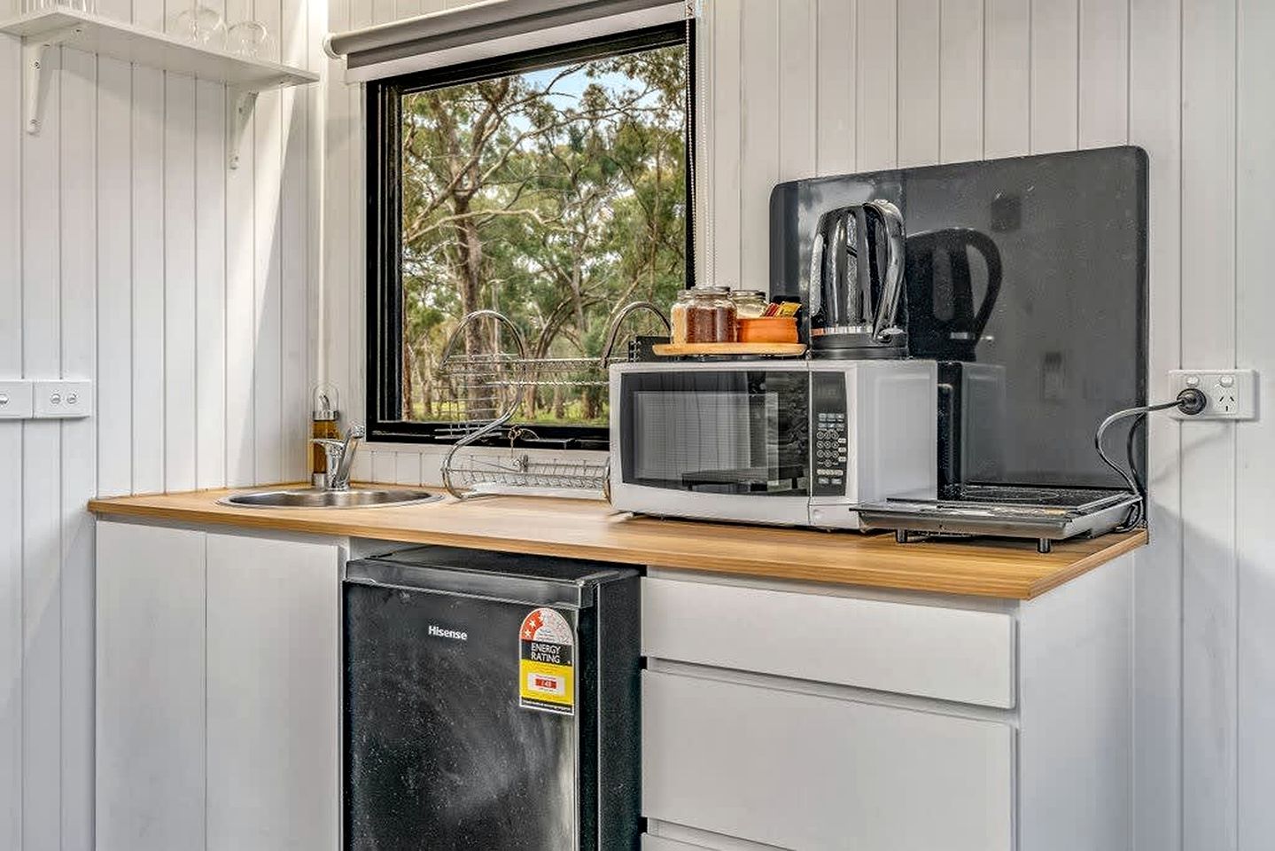 Une petite cuisine équipée d’un four à micro-ondes, d’un grille-pain et d’un petit réfrigérateur.