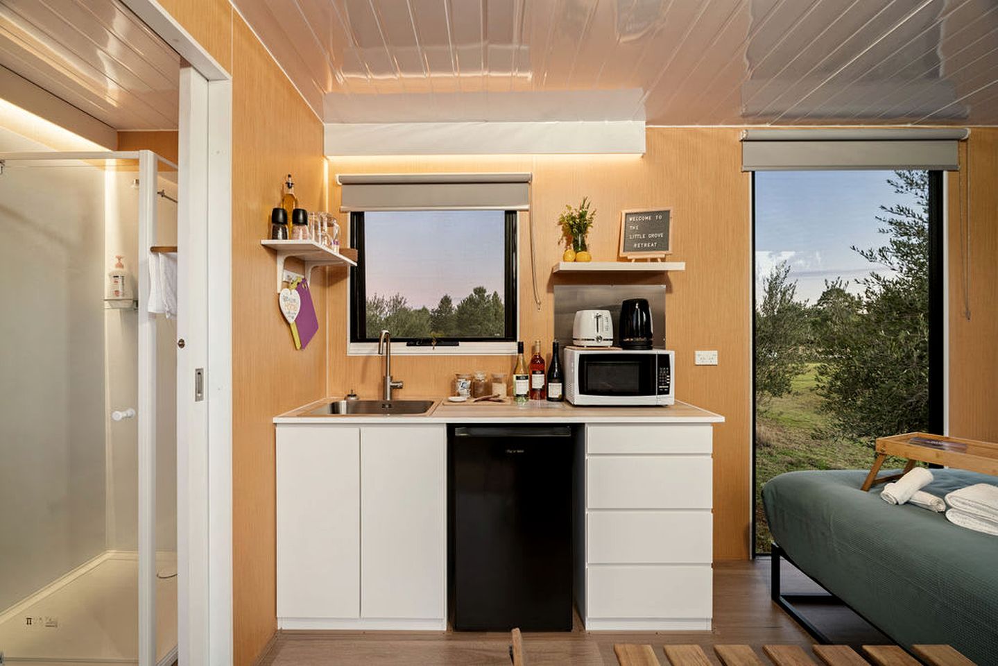 A compact kitchenette with a microwave, coffee maker, and sink.