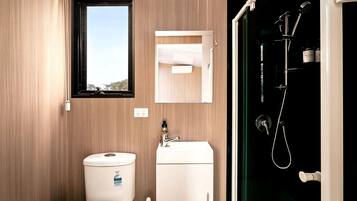 A modern bathroom with a toilet, sink, and shower.