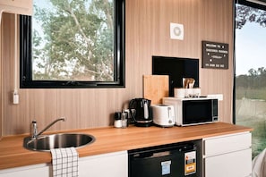 A modern kitchen with a sink, a toaster, a microwave, and a coffee maker.