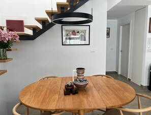 A dining area with a round wooden table, chairs, a vase, and a framed picture on the wall. - Casa del Sol - Exclusive Villa, Private Pool & Jacuzzi (Dolores)