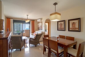 A hotel room with a dining area, a sofa, and a view of the outside. - Apartment in Nerja Near Beaches & Pool (Nerja)