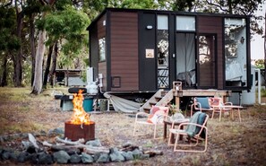A cabin with a fire pit and outdoor seating.