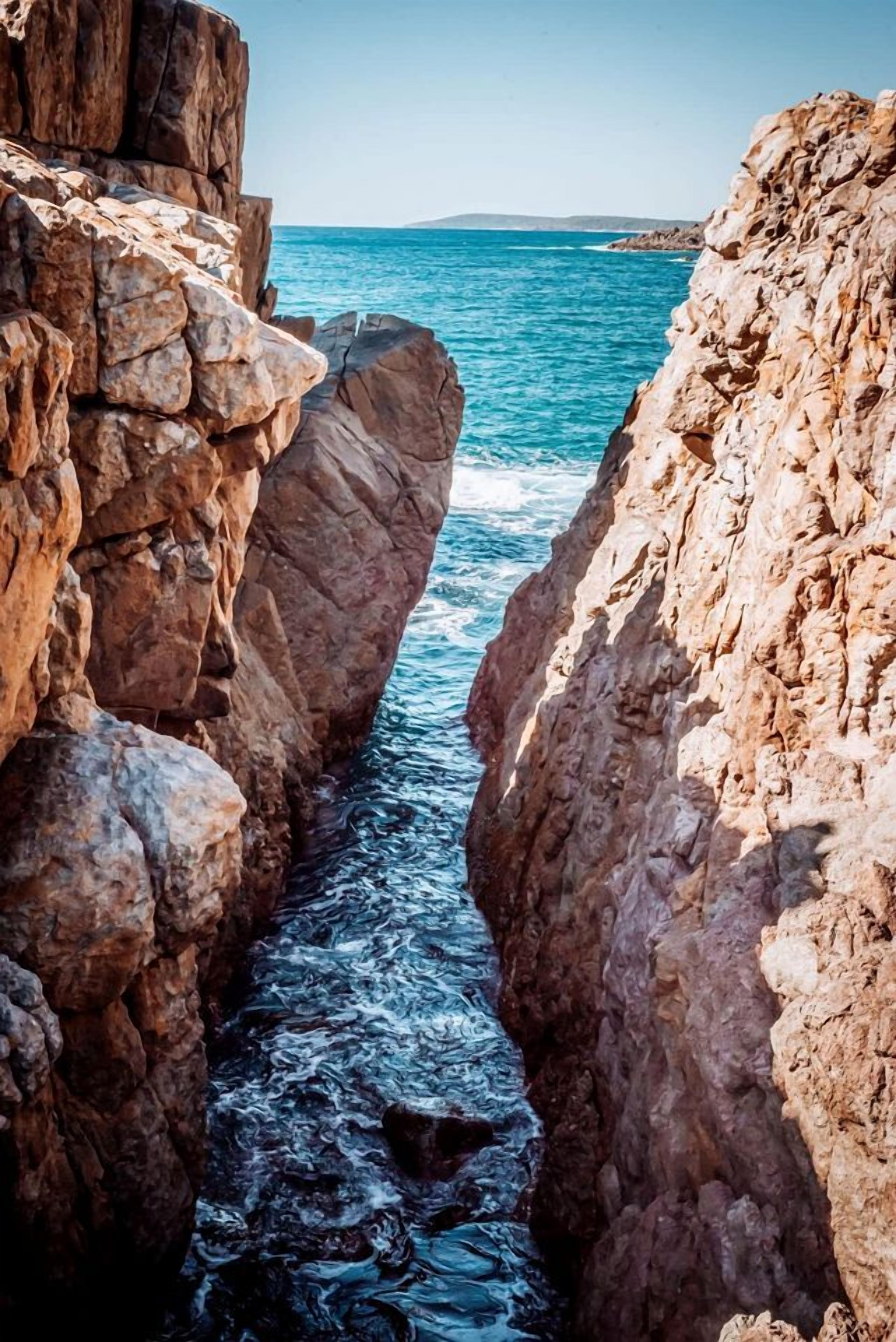 A coastal rock formation with a narrow water channel.