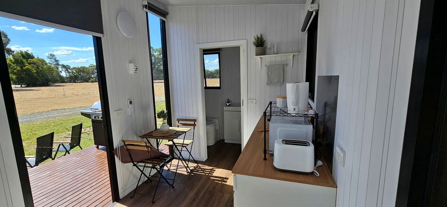 Cocina compacta con comedor, tostadora y vistas al exterior.