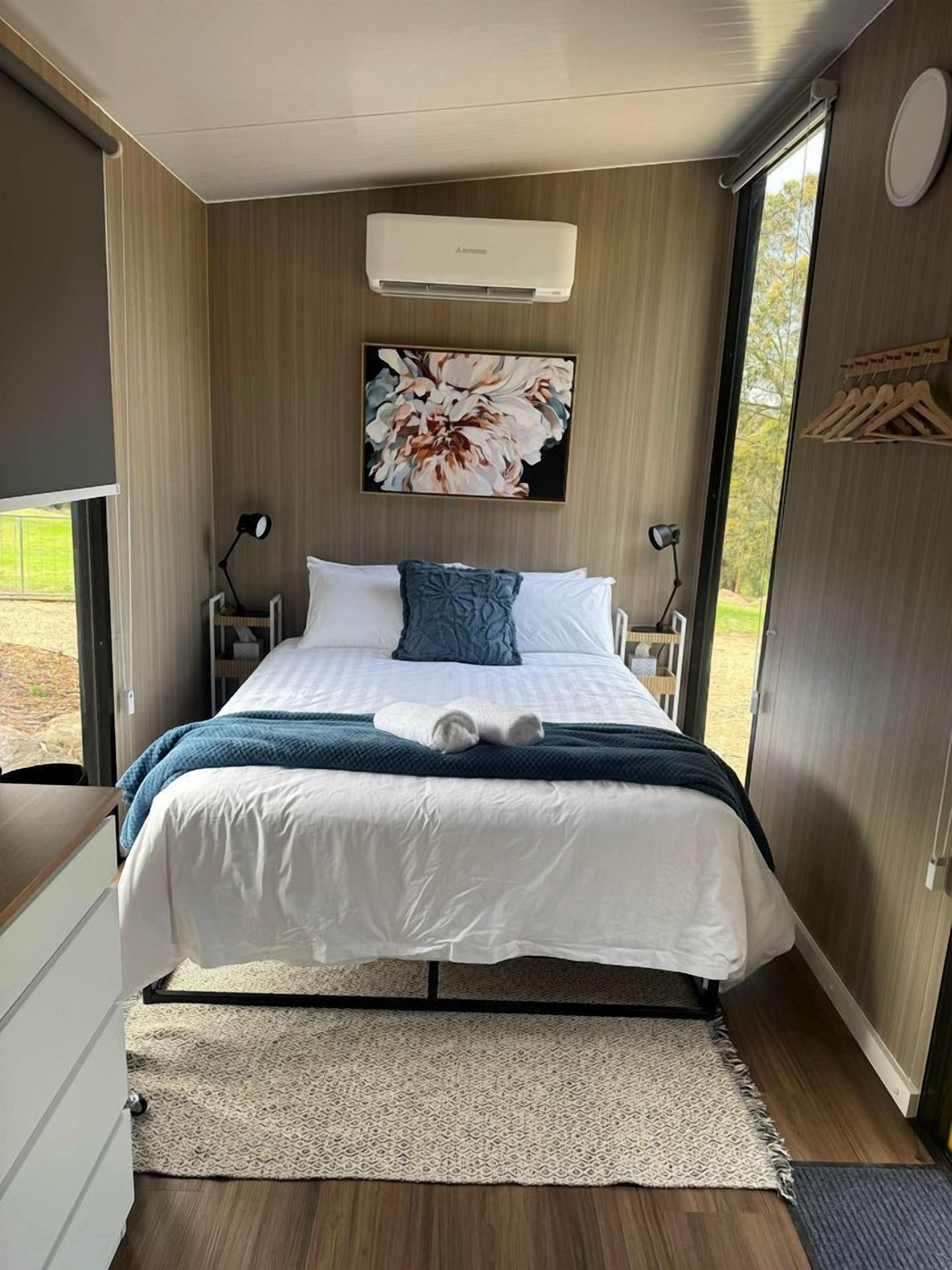 Un dormitorio moderno con una cama grande, aire acondicionado instalado y vistas al exterior.