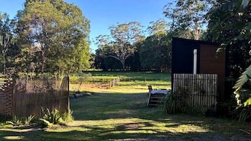 Un patio cercado con un sendero de grava que lleva a una estructura de madera.