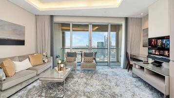 A modern living room with a sofa, chairs, a coffee table, and a TV.