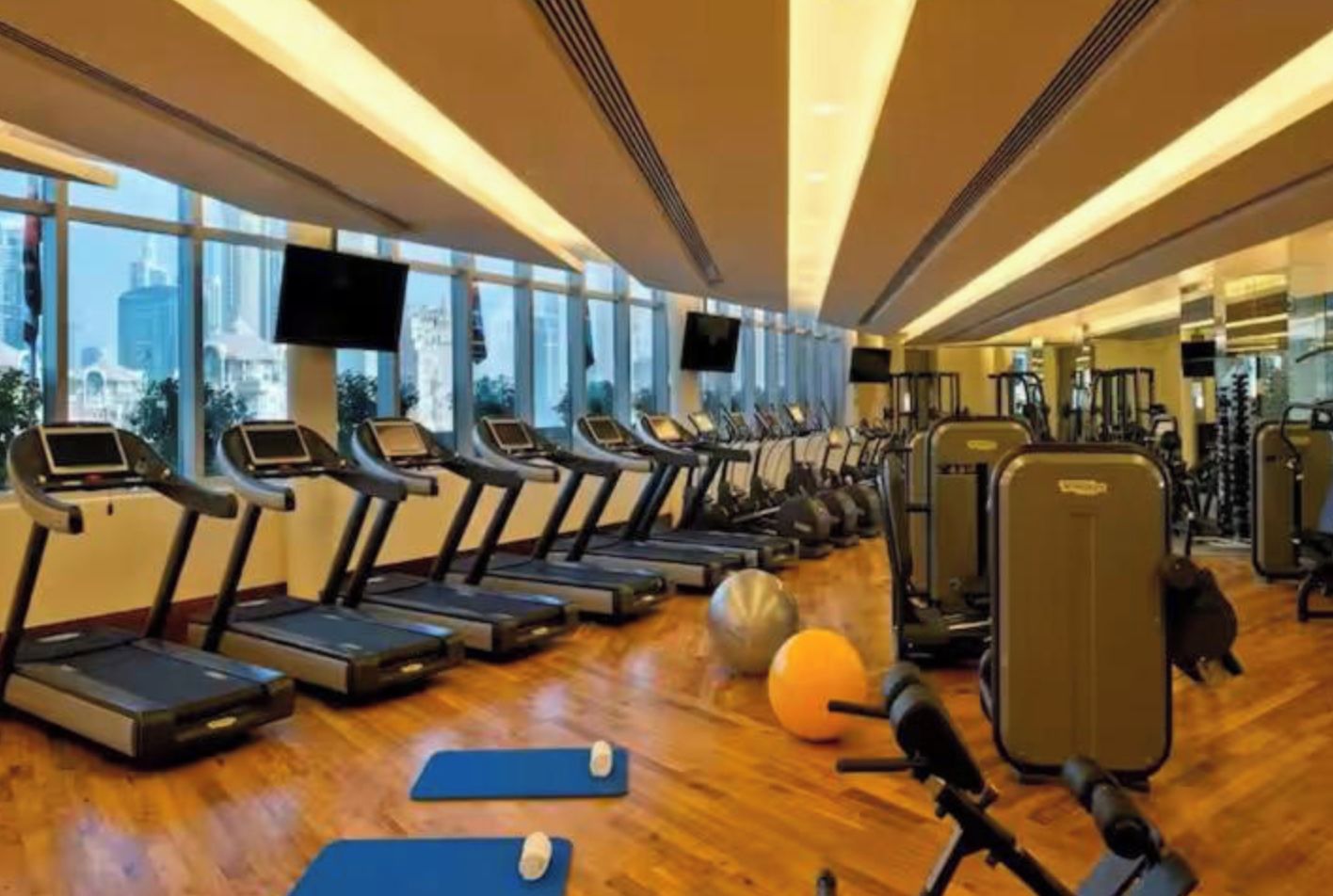 A gym with treadmills, exercise balls, and weights.
