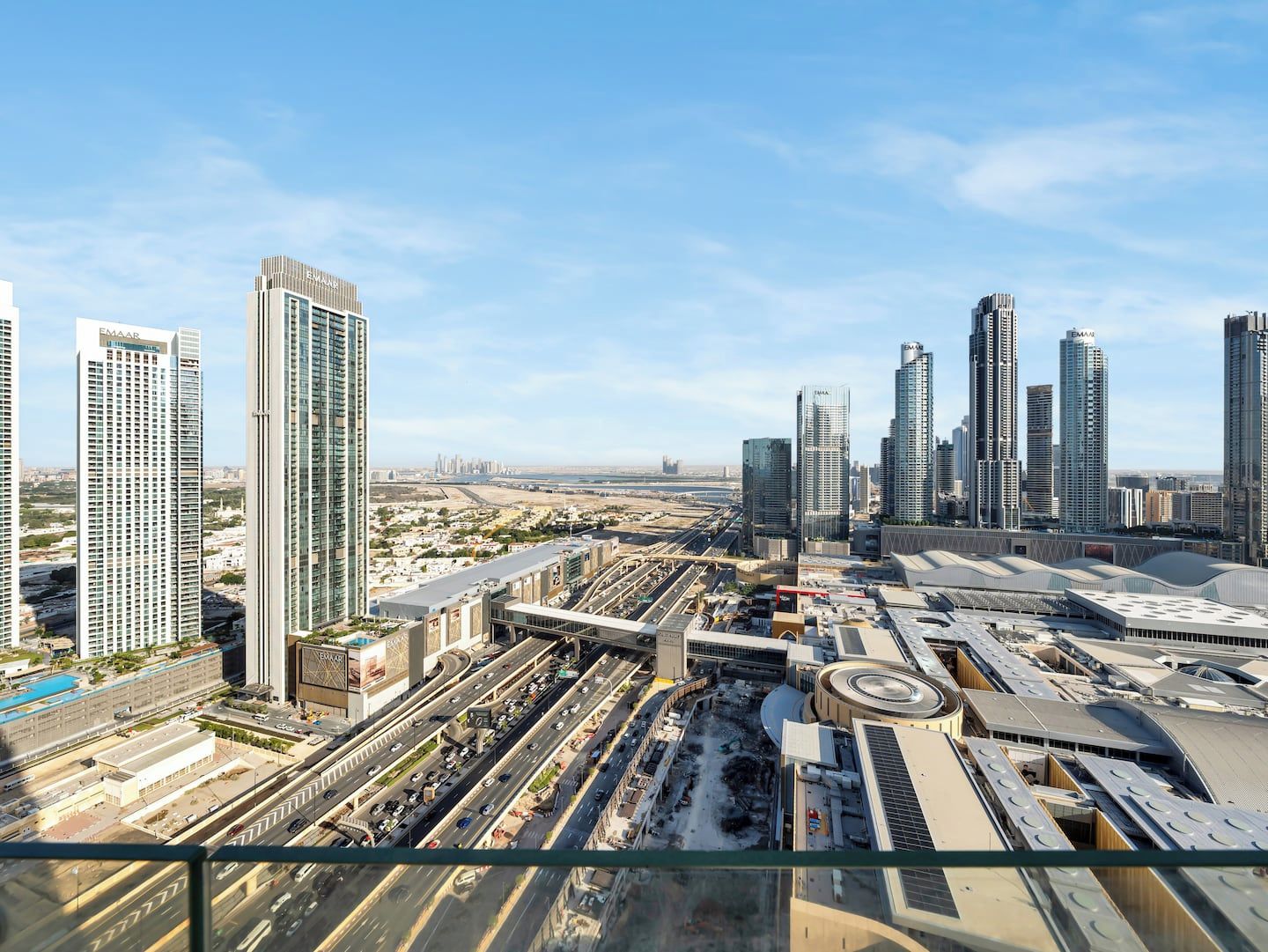A high-rise building with multiple floors, a large parking structure, and a busy road network.