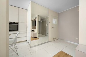 A modern kitchen with a built-in oven and a white chair. - Wroclaw | 29 Budziszyńska | Bright Apartment | Coffee machine (Wrocław)