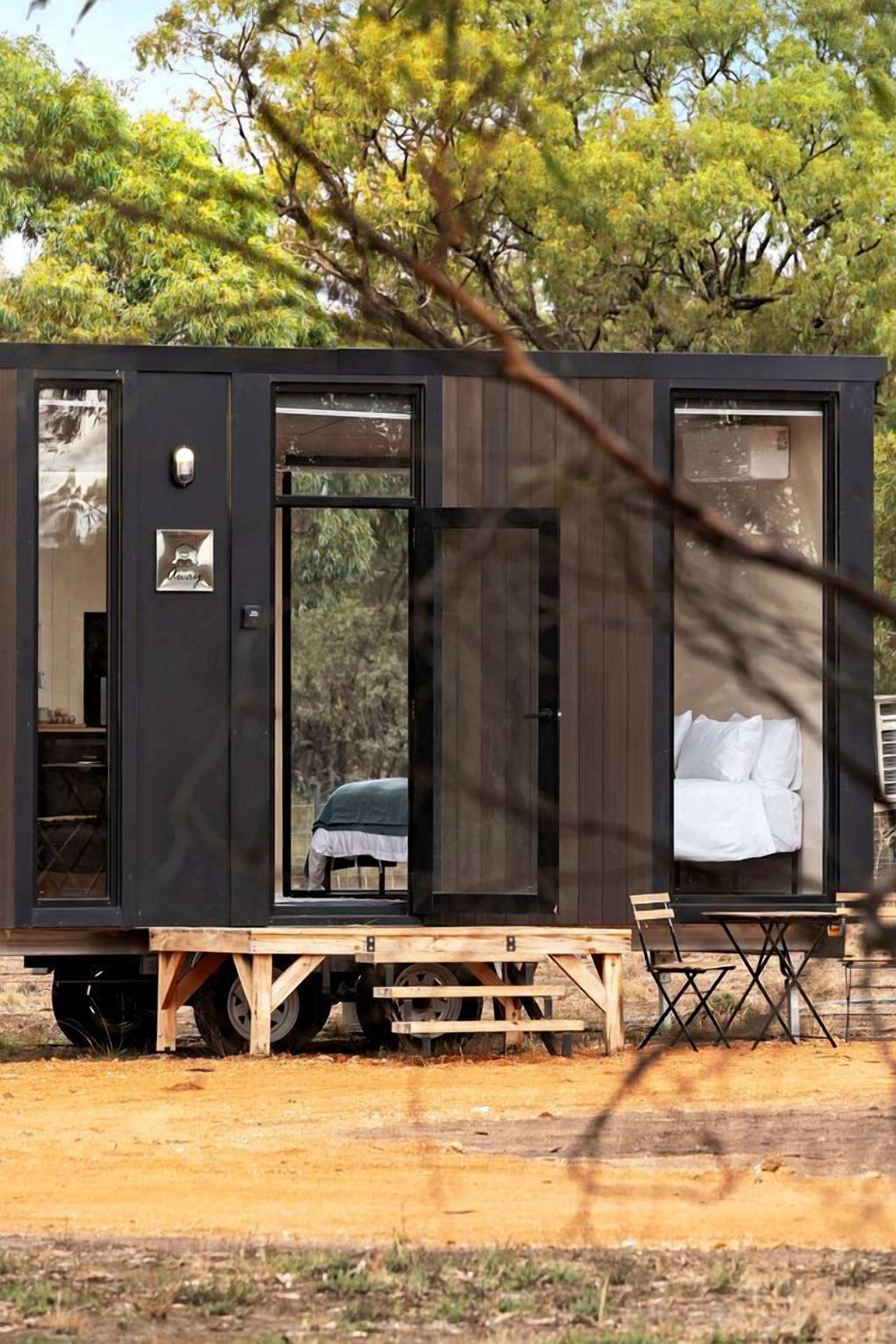 A mobile home with a bed, a table, and a bench.